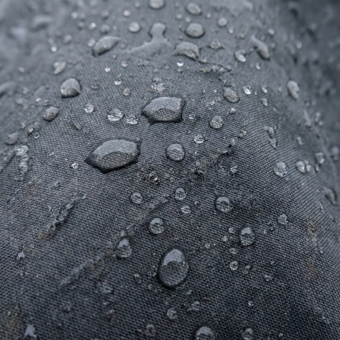 Water droplets beading technical raincoat fabric macro detail grey