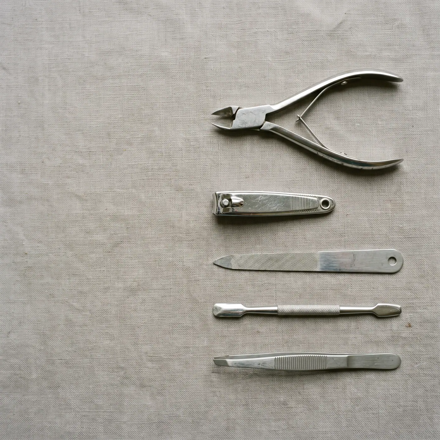 Nail clippers set flat lay, neutral surface, copy space, top view