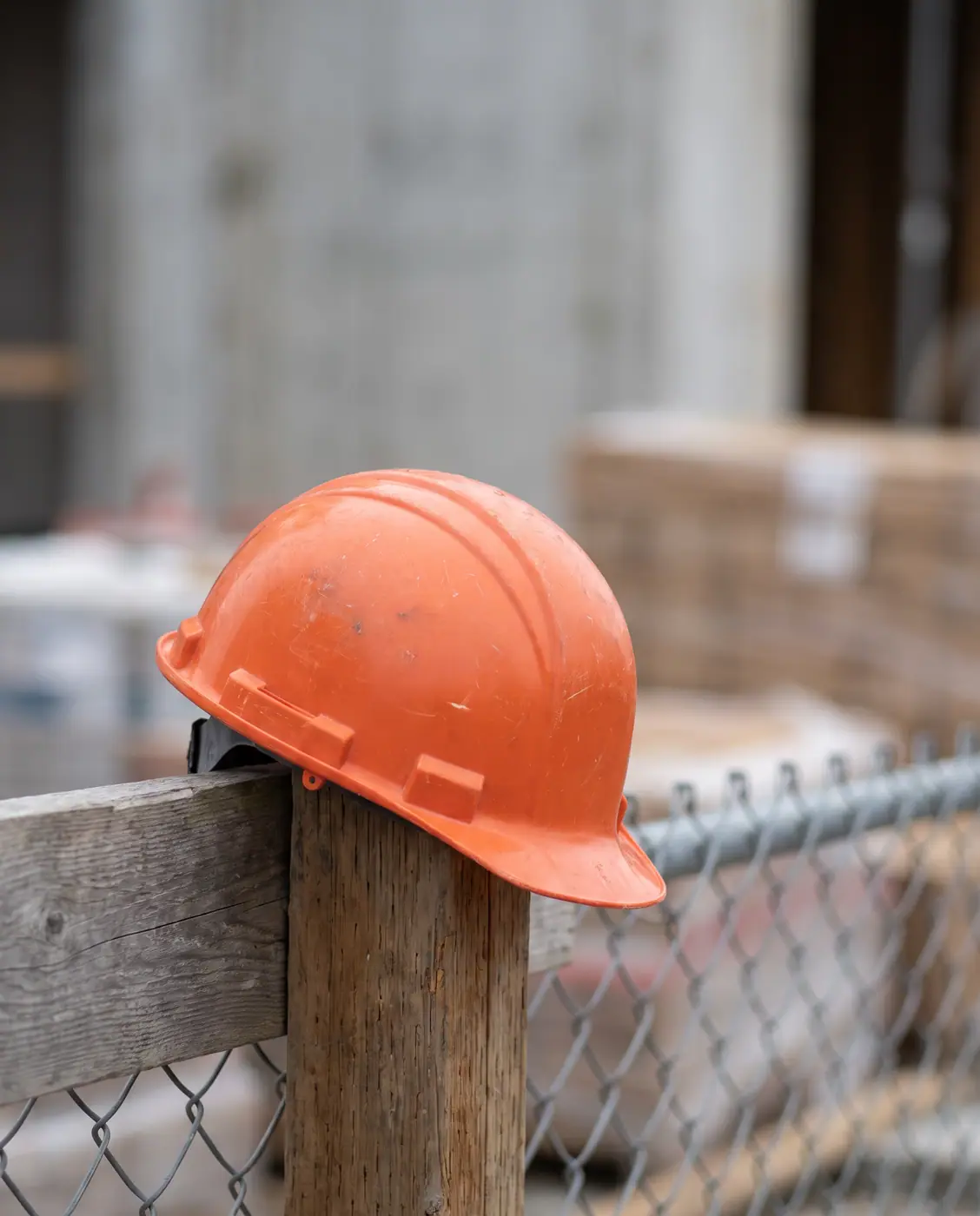 Industrial Safety Helmet on Construction Site Fence Post