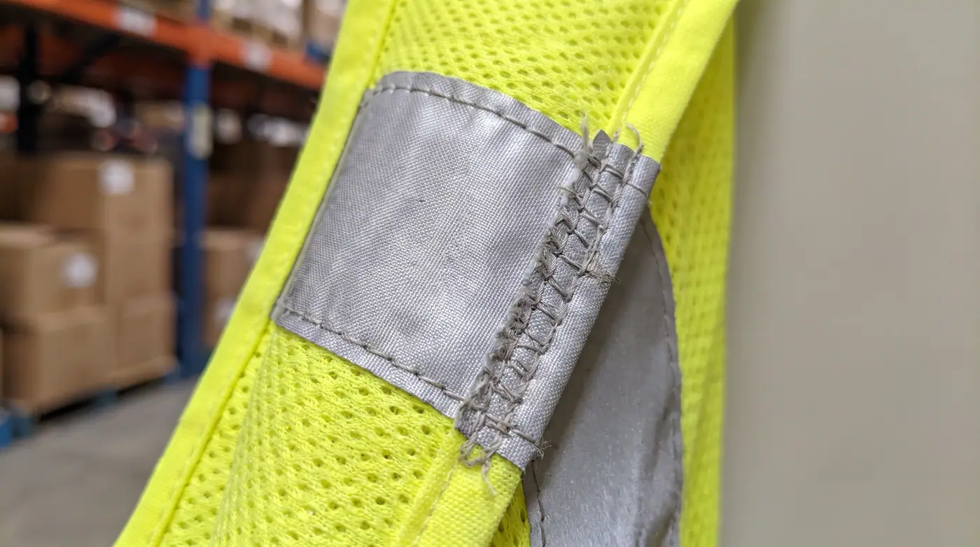 High-visibility reflective safety vest fabric edge stitching