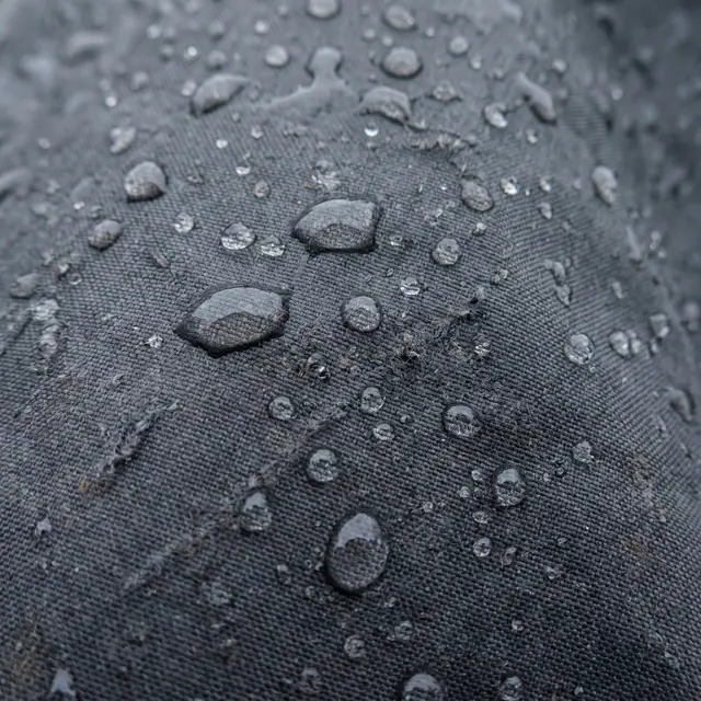 Water droplets beading technical raincoat fabric macro detail grey
