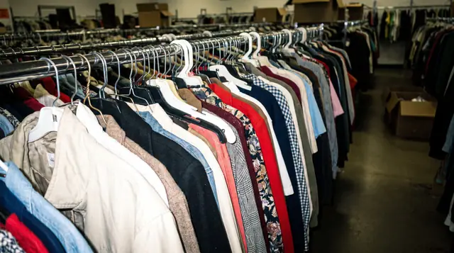 Second-hand clothing rail thrift shop mixed colours fabrics hangers