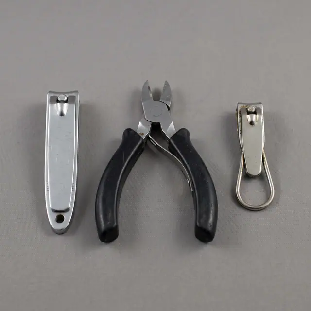 Three nail clippers variants side by side neutral background