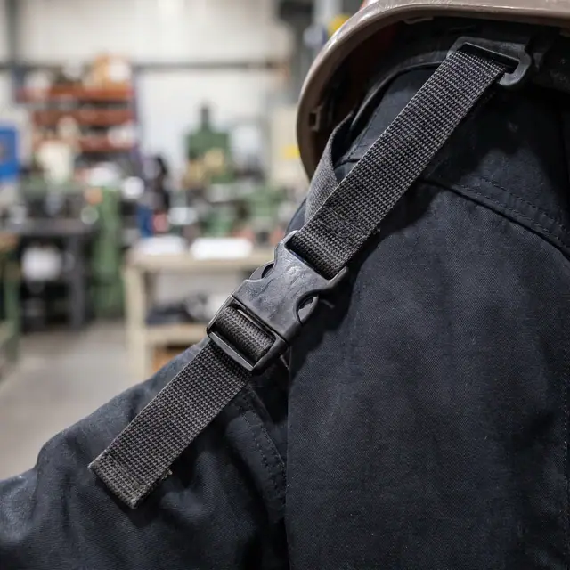 Safety helmet chinstrap buckle close-up industrial side view